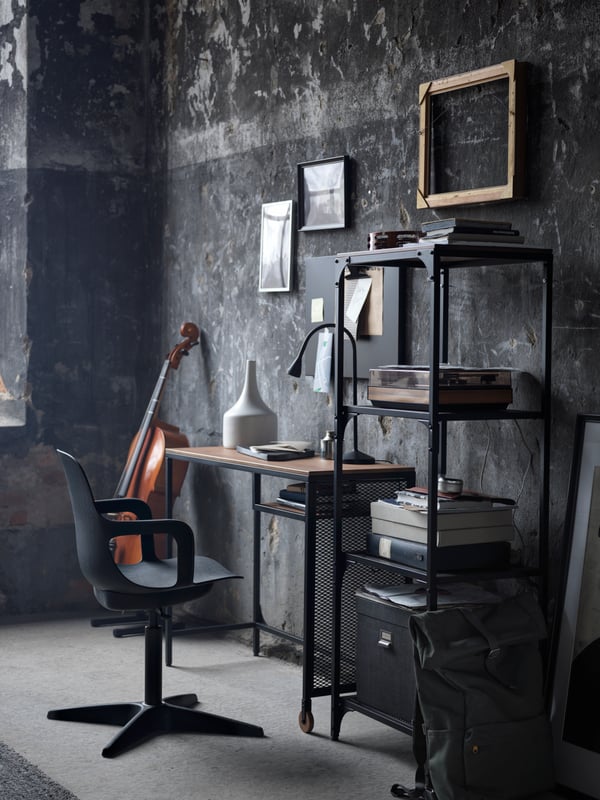 A compact workspace formed by a black FJÄLLBO laptop table, a FJÄLLBO shelving unit, and an anthracite ODGER swivel chair.