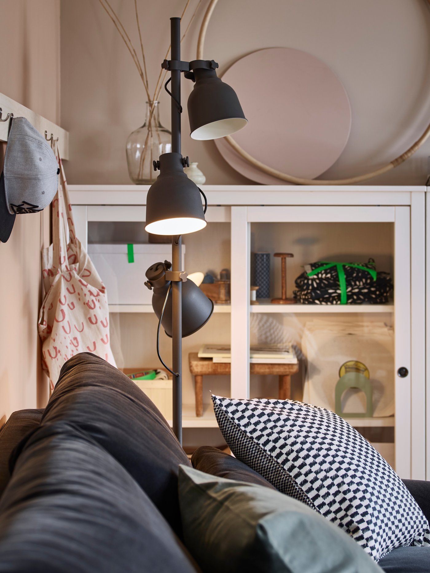 A dark grey HEKTAR floor lamp with 3-spot in the living room