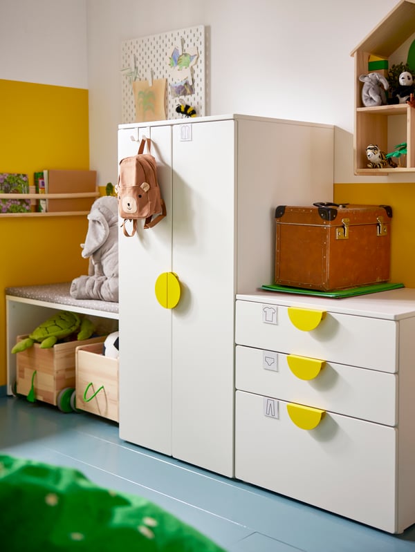 SMÅSTAD storage combination with the doors and drawers closed, some bags and soft toys placed on top of it.