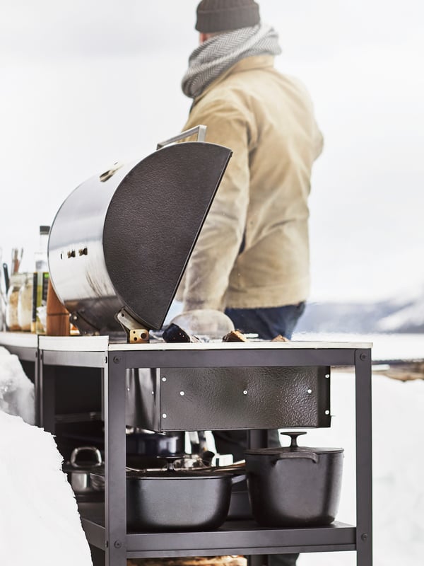 A black/stainless steel outdoor GRILLSKÄR charcoal barbecue