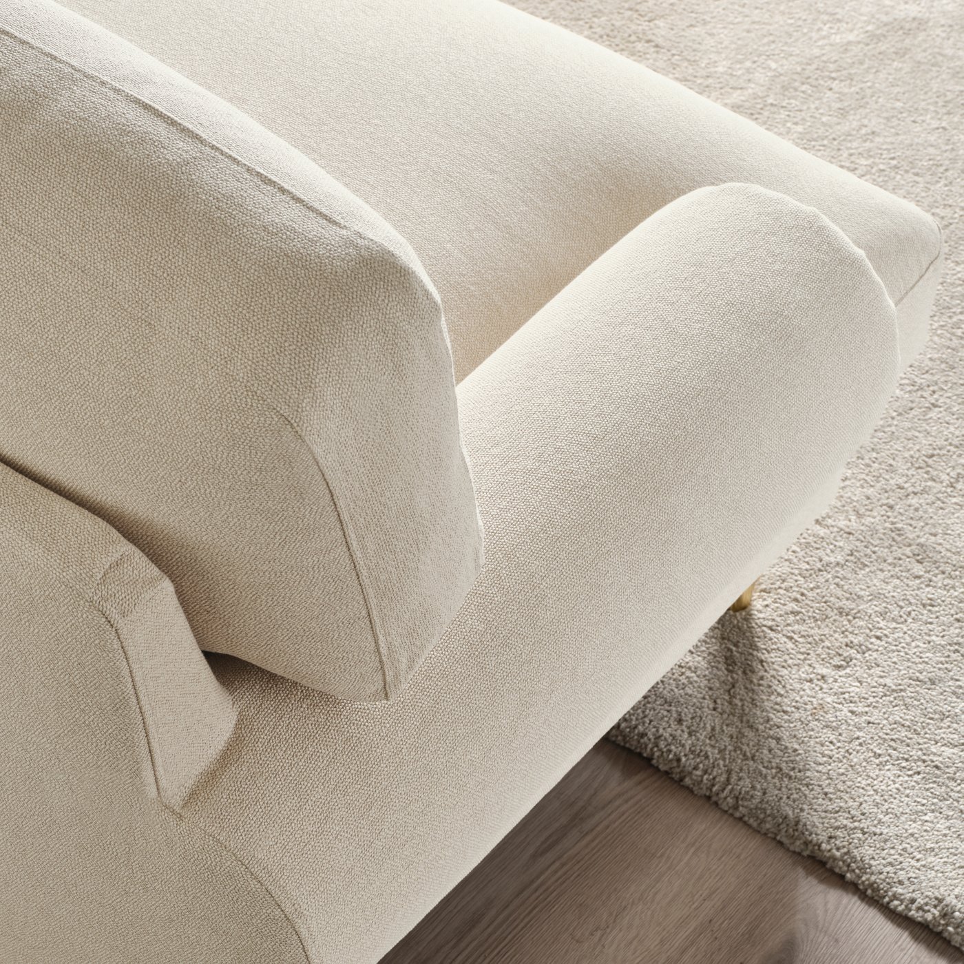 Närbild på den mjukt formade ryggen och armstödet på VALNÄS soffa i ljusbeige, strukturerat tyg.
