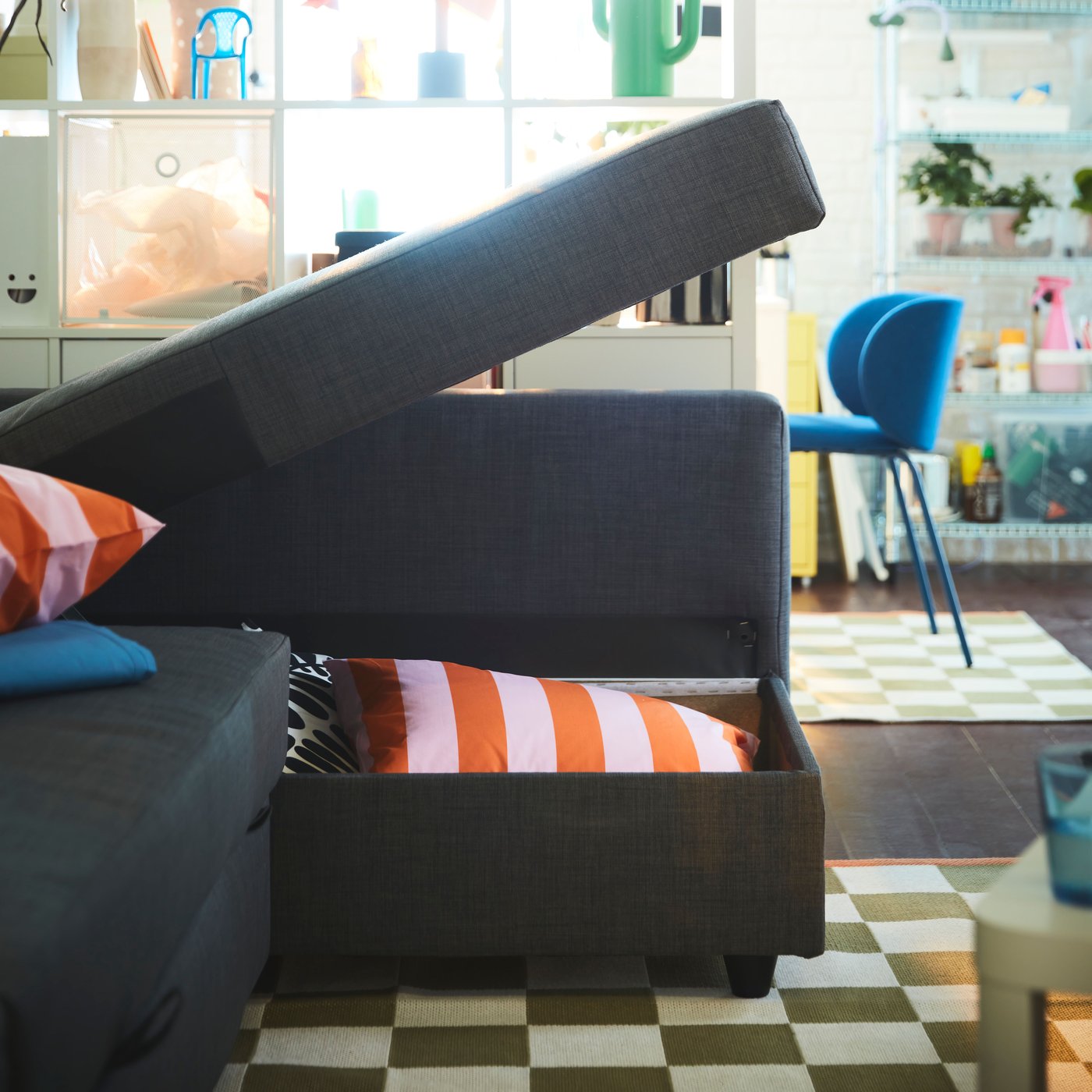 A dark gray FRIHETEN corner sleeper sofa with storage, partially opened to reveal cushions inside.