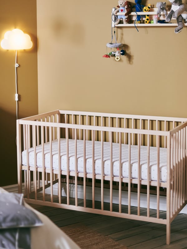 Un lit d’enfant SNIGLAR combiné à un rangement mural FLISAT crée un coin bébé accueillant en bois naturel.