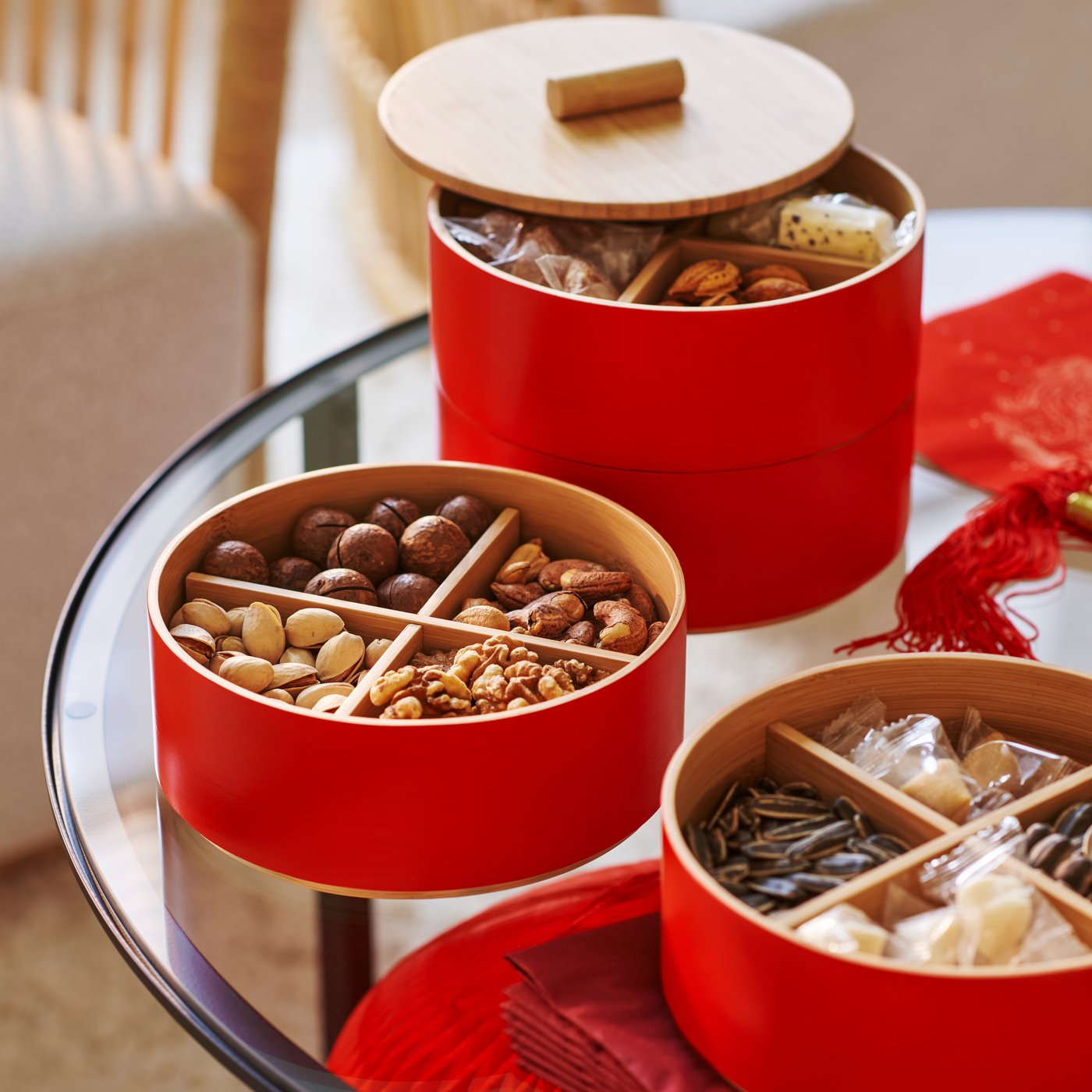 A glass table with several FÖSSTA serving containers with lid, open and filled with various seeds and nuts.