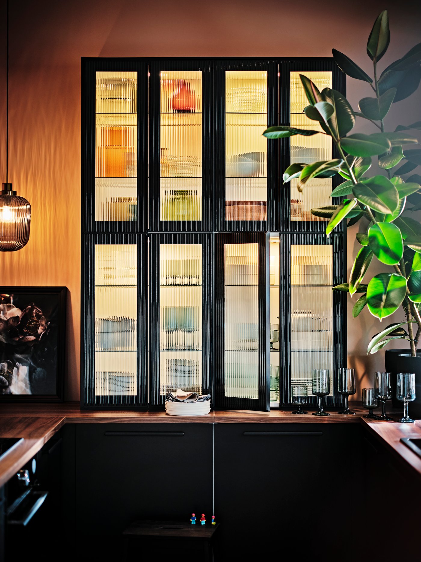 A kitchen with glass HEJSTA top cabinet doors.