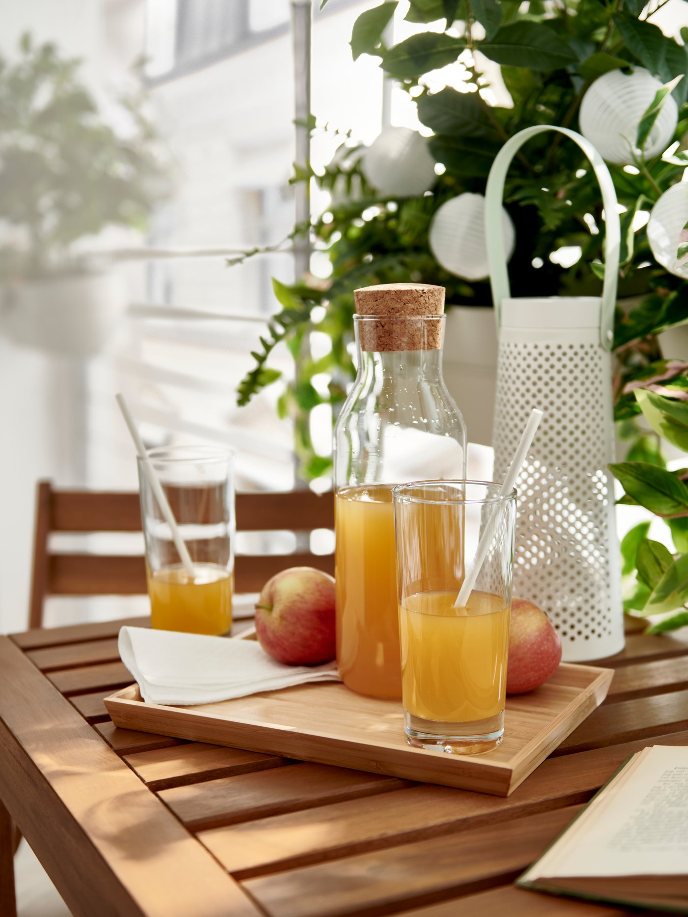 Un par de vasos de vidrio sobre una bandeja de madera con jugo de durazno