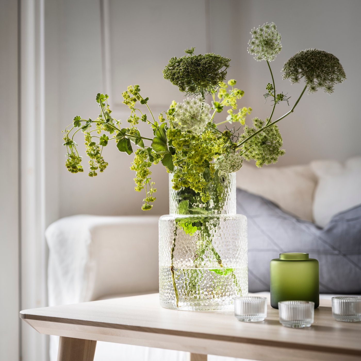 A clear glass/patterned KONSTFULL vase in the living room