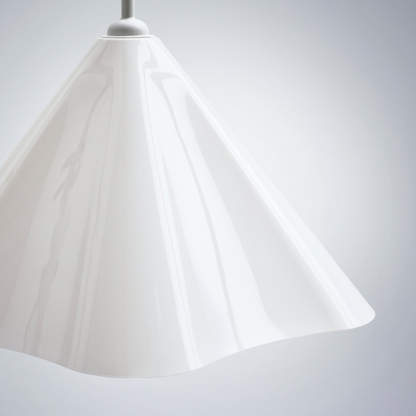A close-up of a white plastic ZEBRASÄV pendant lamp against a white background, highlighting its asymmetrical shape.