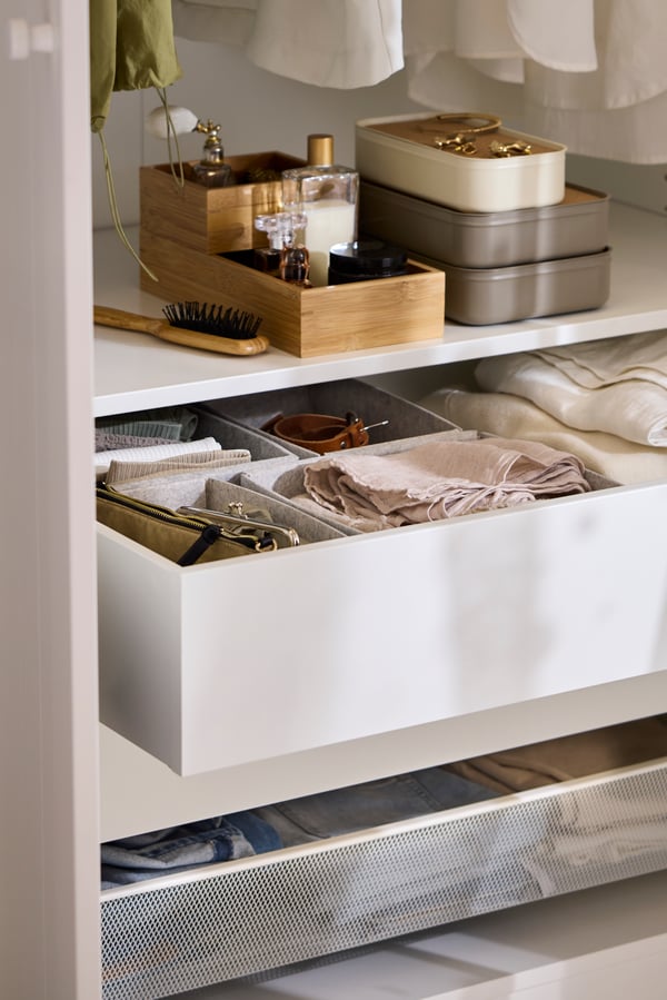 An open drawer in a white PAX/GULLABERG wardrobe showing different KOMPLEMENT boxes inside holding accessories.