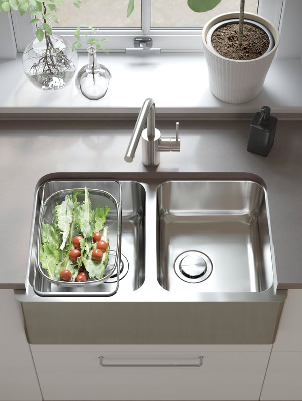 A worktop with an IKEA BREDSJÖN stainless steel kitchen sink with two bowls and a visible front.