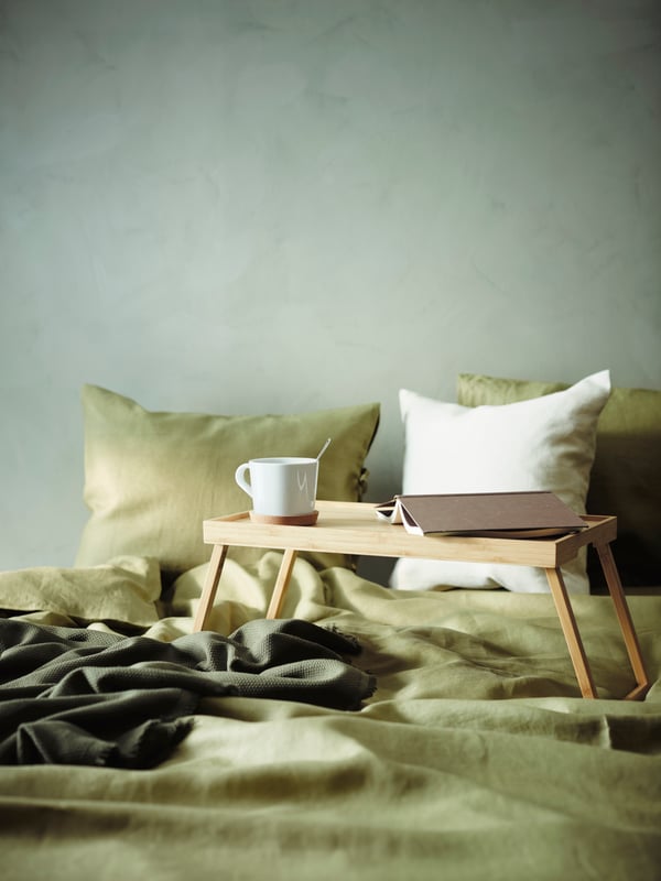 RESGODS bed tray placed on a bed with green bed linen.