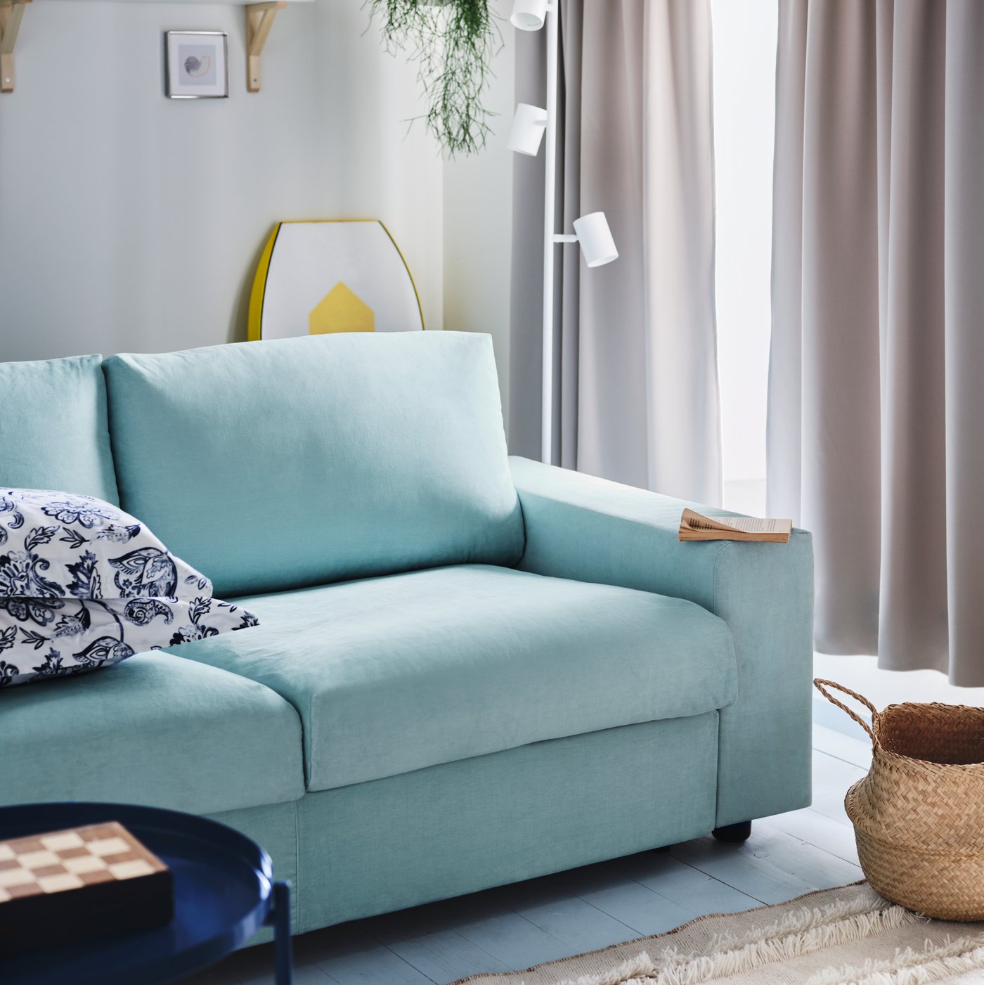 A blue KIVIK sofa in the living room with the curtains closed.