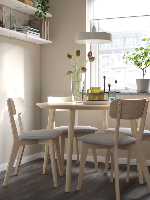 Un comedor redondo de madera con sillas de comedor LISABO.