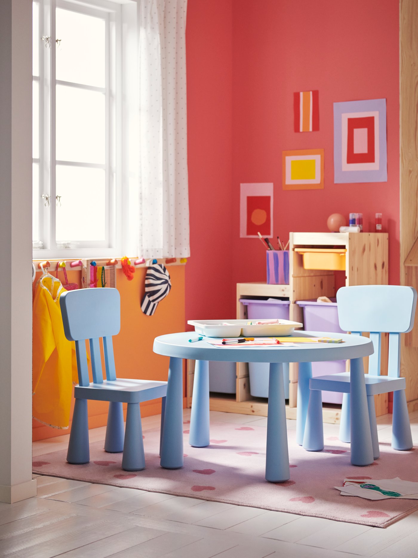 A playroom features a light blue MAMMUT children`s table with two matching chairs, surrounded by colourful wall art.
