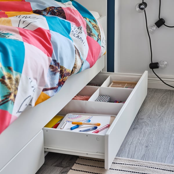 Una habitación de niña con una cama nido con almacenamiento SLÄKT.