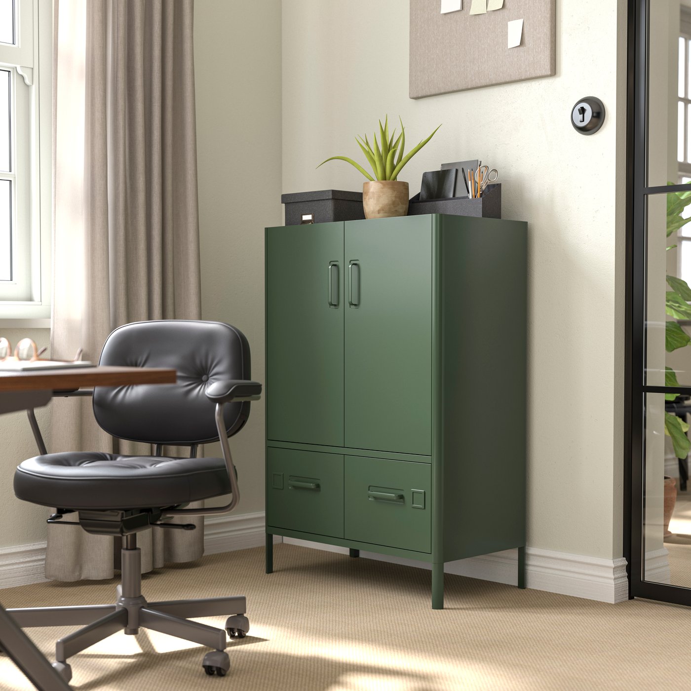 Une armoire IDÅSEN vert foncé avec portes et tiroirs est placée dans un bureau.