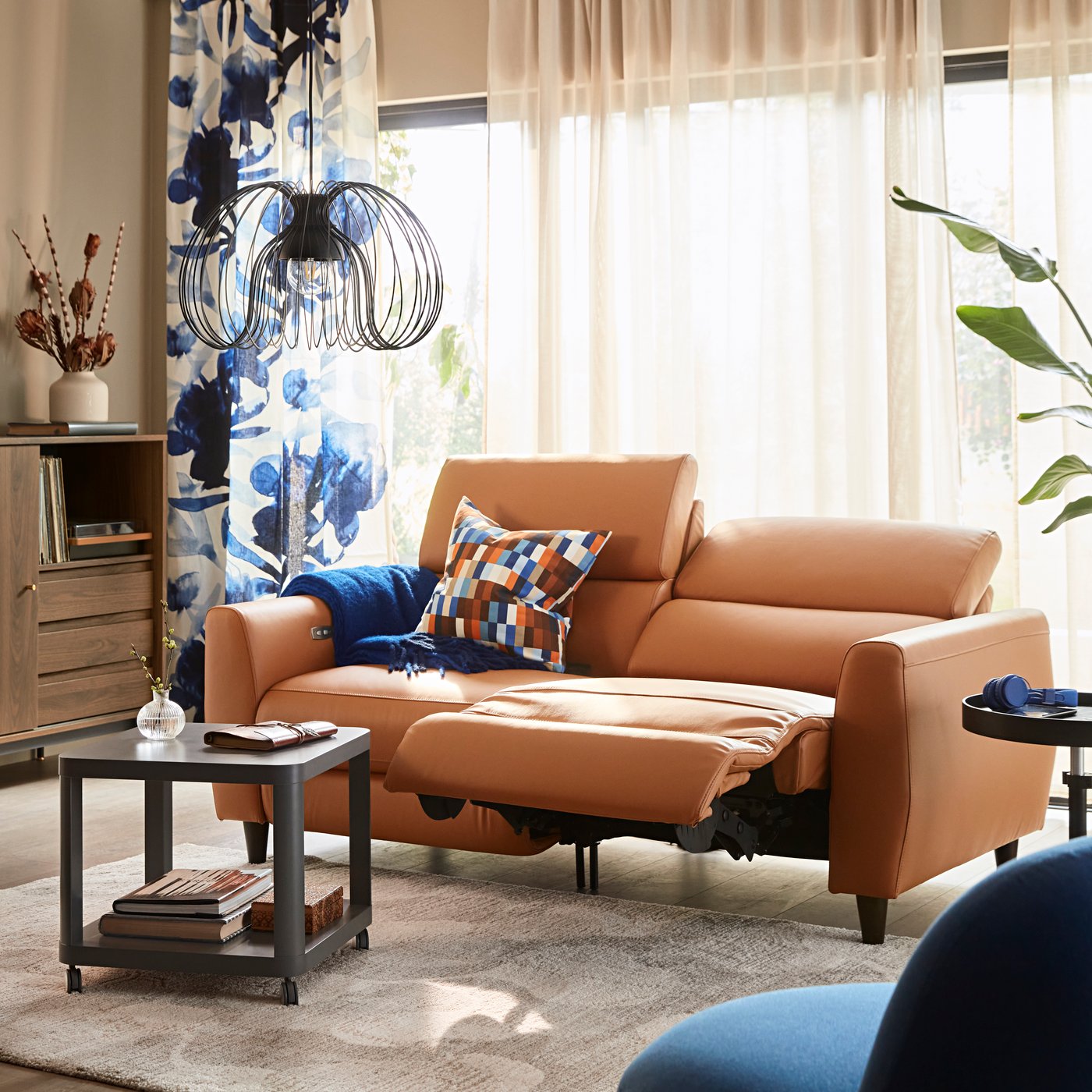 A Grann/Bomstad golden-brown RULLERUM 2-seat sofa with electric recliner in the living room