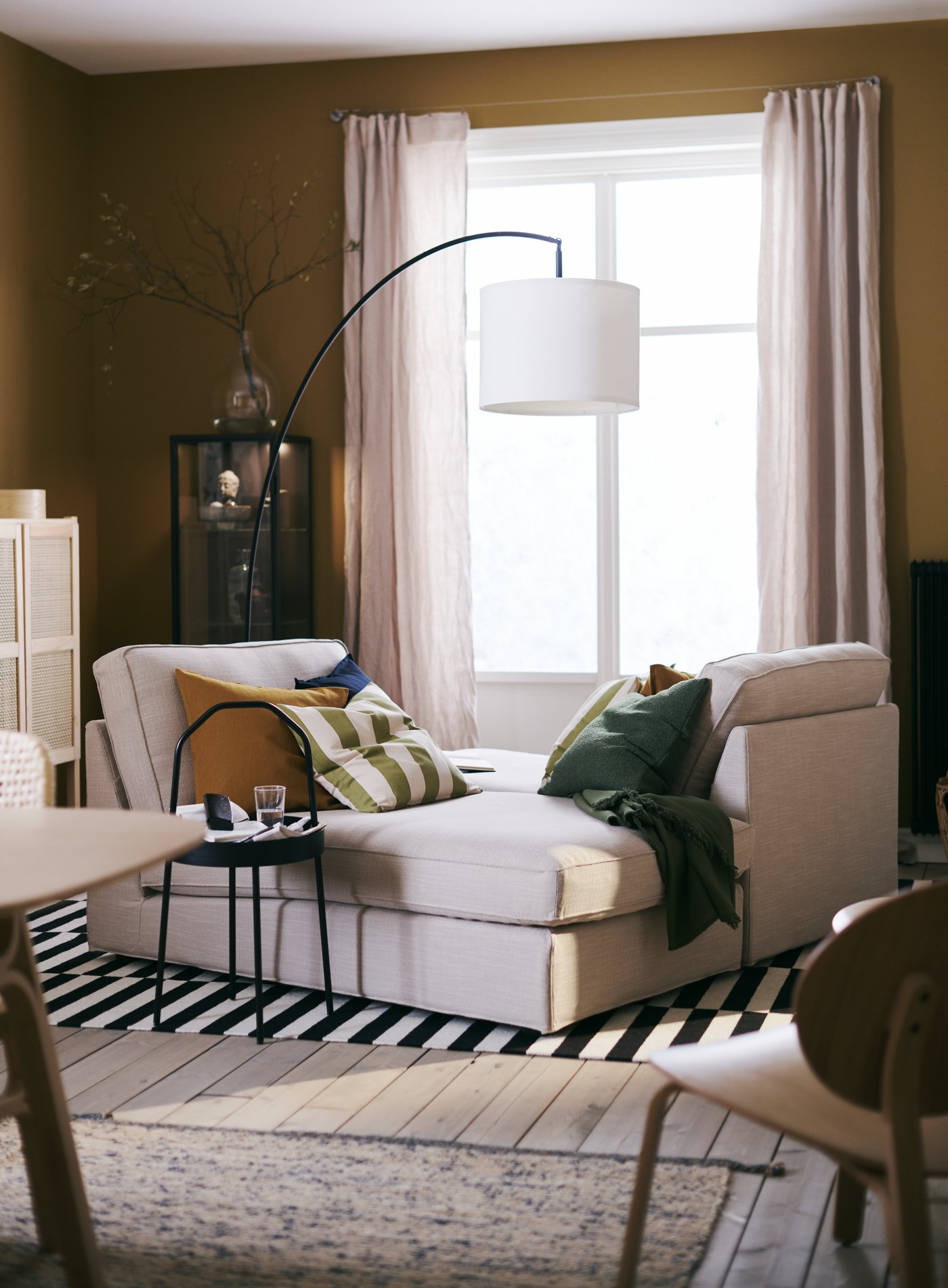 A black SKAFTET floor lamp base, arched in the living room
