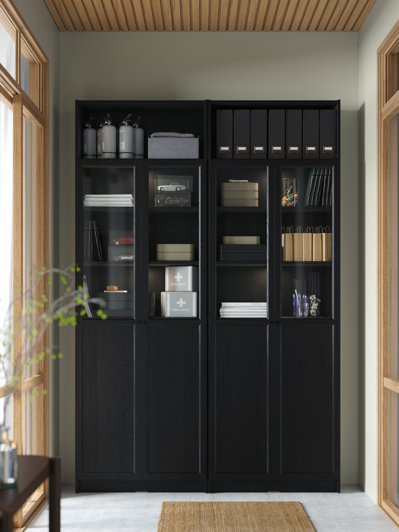 A large black BILLY bookcase combination with closed doors,  glass doors and open shelves. A rug in natural fibre.