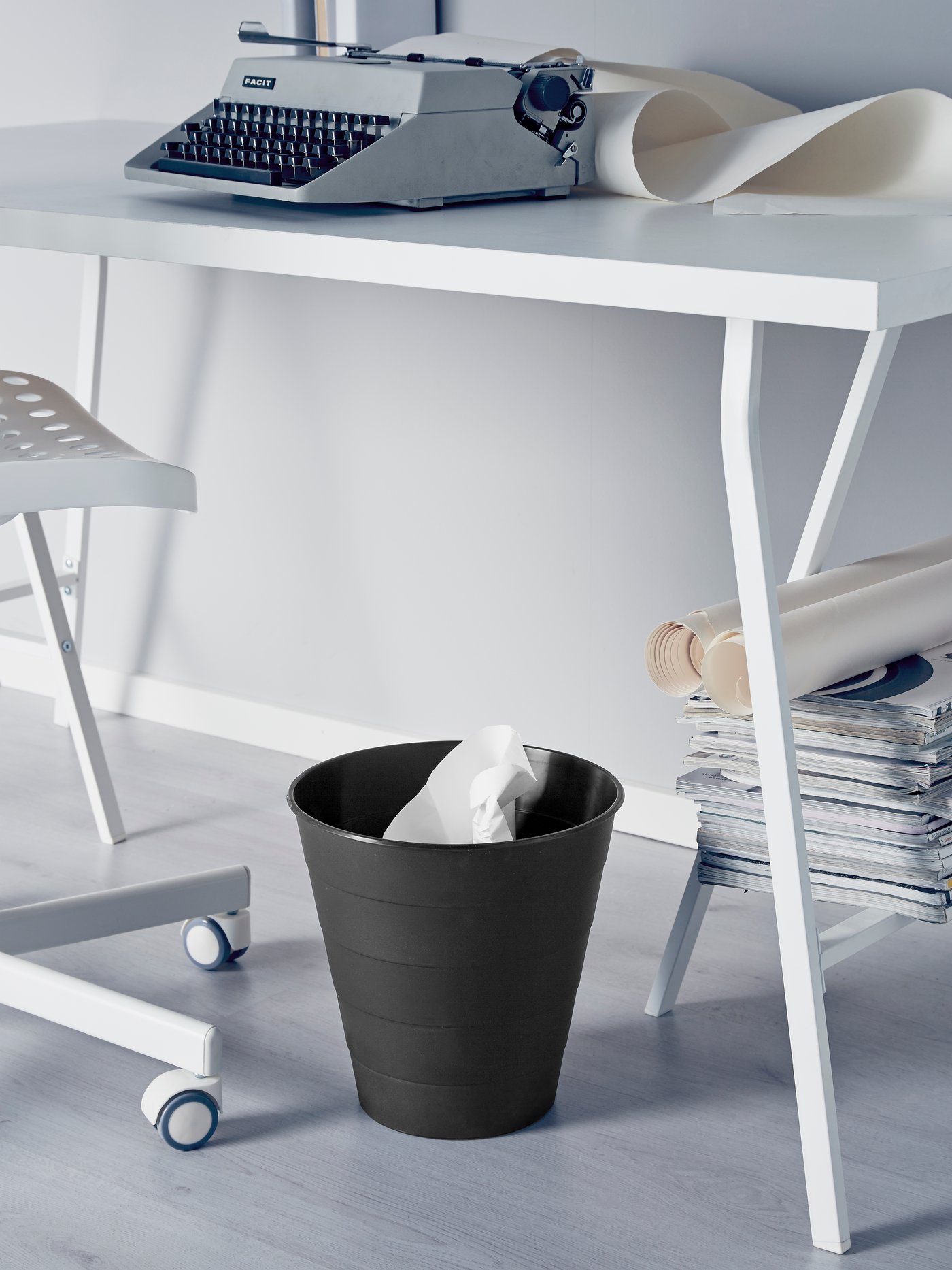Una caneca FNISS negra debajo de un escritorio.