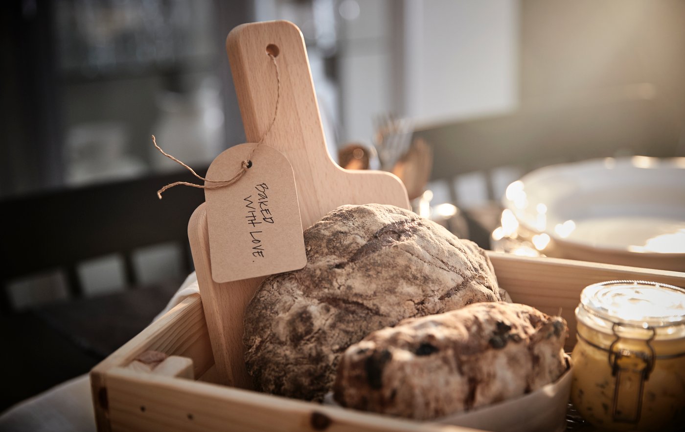 Sorprendi amici e parenti con un'idea regalo fai-da-te che dura nel tempo, come questo contenitore in legno con un tagliere, del pane e un barattolo di burro - IKEA