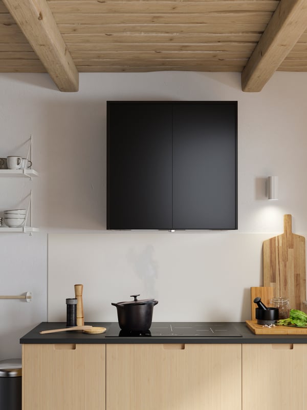 An under cabinet extractor hood with anthracite doors, a matte anthracite worktop and light bamboo drawer fronts.