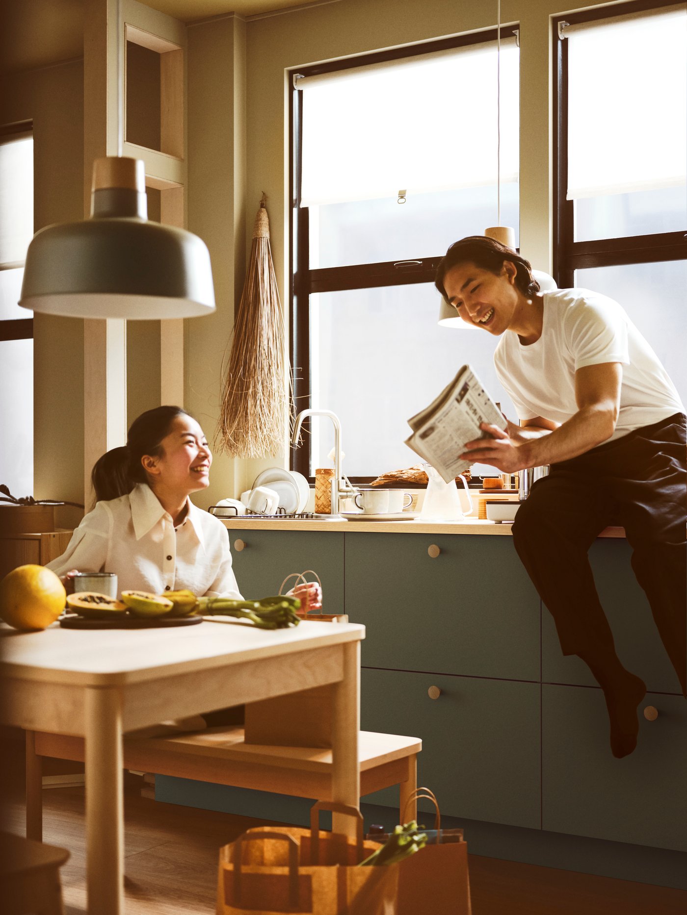 Ein Mann und eine Frau in einer Wohnküche von IKEA mit Bank und Tisch aus der RÖNNINGE Serie.