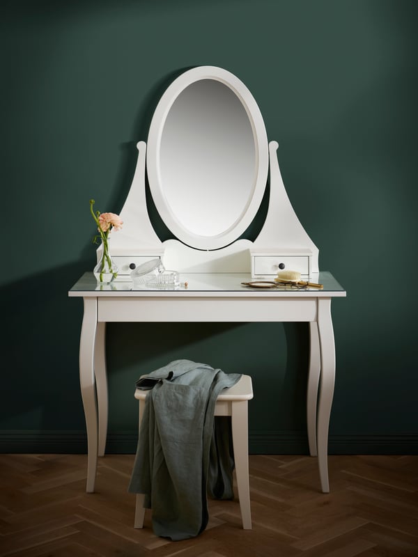 Un tocador HEMNES blanco con espejo en una recámara.
