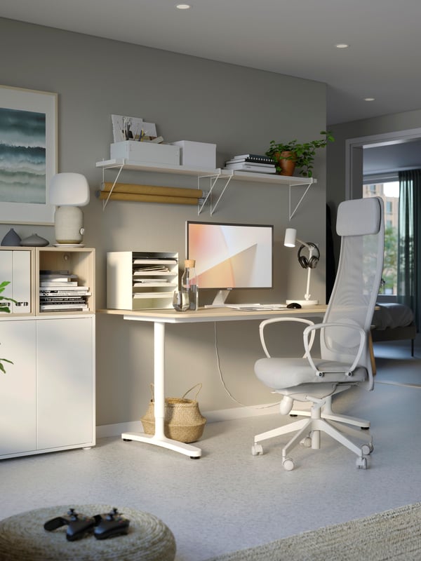 Un espacio amplio con un escritorio de altura ajustable y una silla gamer MARKUS.