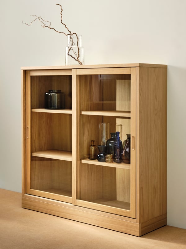 Vitrine en bois clair avec déco minimaliste de vases en différentes couleurs