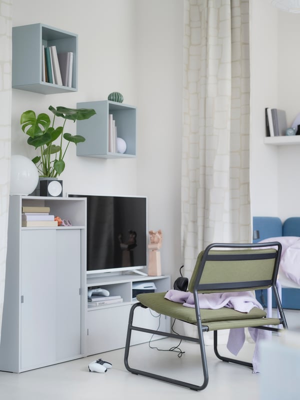 Fleksibilna gejmerska zona sa SPIKSMED TV stalažom i elementom svetlosive boje i maslinastozelenom LINNEBÄCK foteljom bez rukohvata.