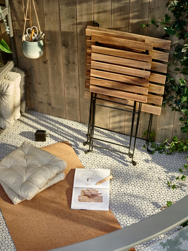 Una terraza con piso para exterior ALTAPPEN blanco y sobre él un tapete y unos cojines MALINDA.