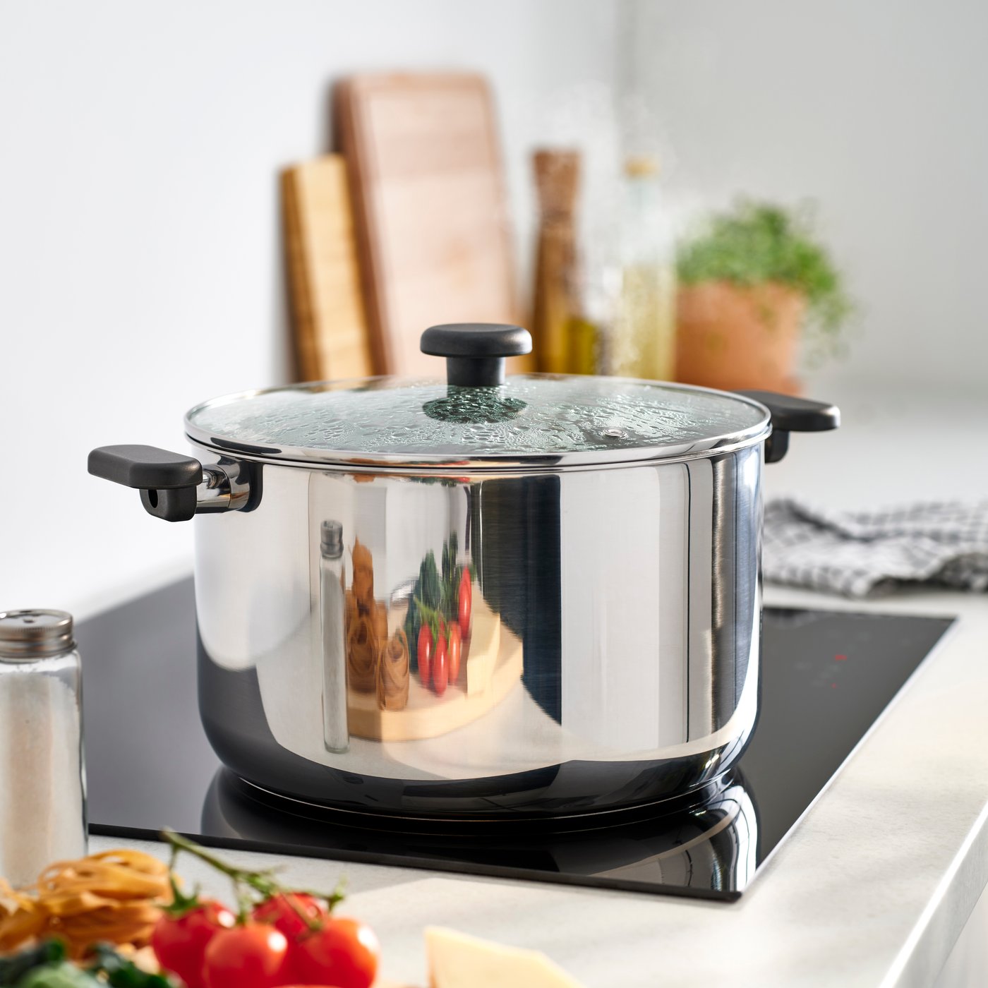 A clear glass/stainless steel MIDDAGSMAT pot with lid in the kitchen