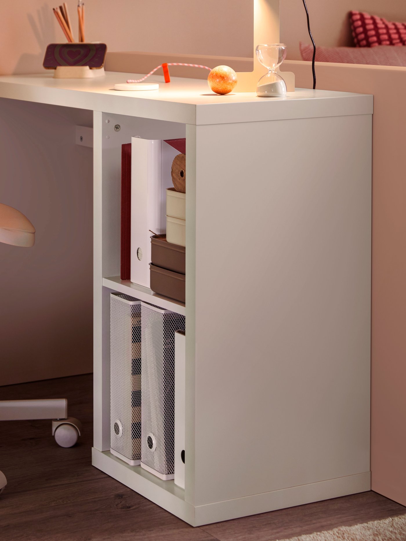 A white KALLAX desk with DRÖNJÖNS and KUGGIS magazine files, a beige desk lamp and a white LOBERGET/MALSKÄR swivel chair.
