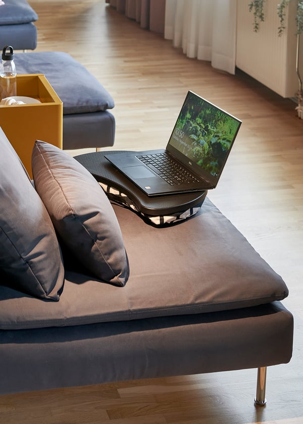 Detaljbild på en SÖDERHAMN mörkgrå 1-sits sektion med en uppfälld laptop, 