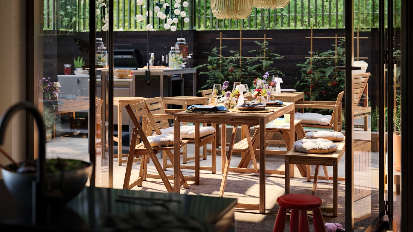 A sunny patio with a dining area furnished with mainly NÄMMARÖ outdoor furniture and a BÅTSKÄR outdoor kitchen with barbeque.