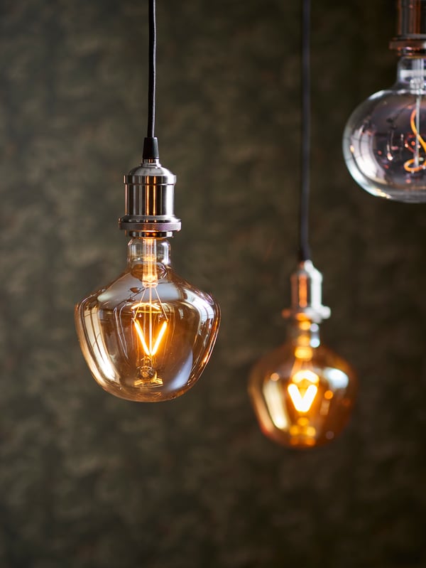 Dos ampolletas LED MOLNART encendidas colgando de cables JÄLLBY.