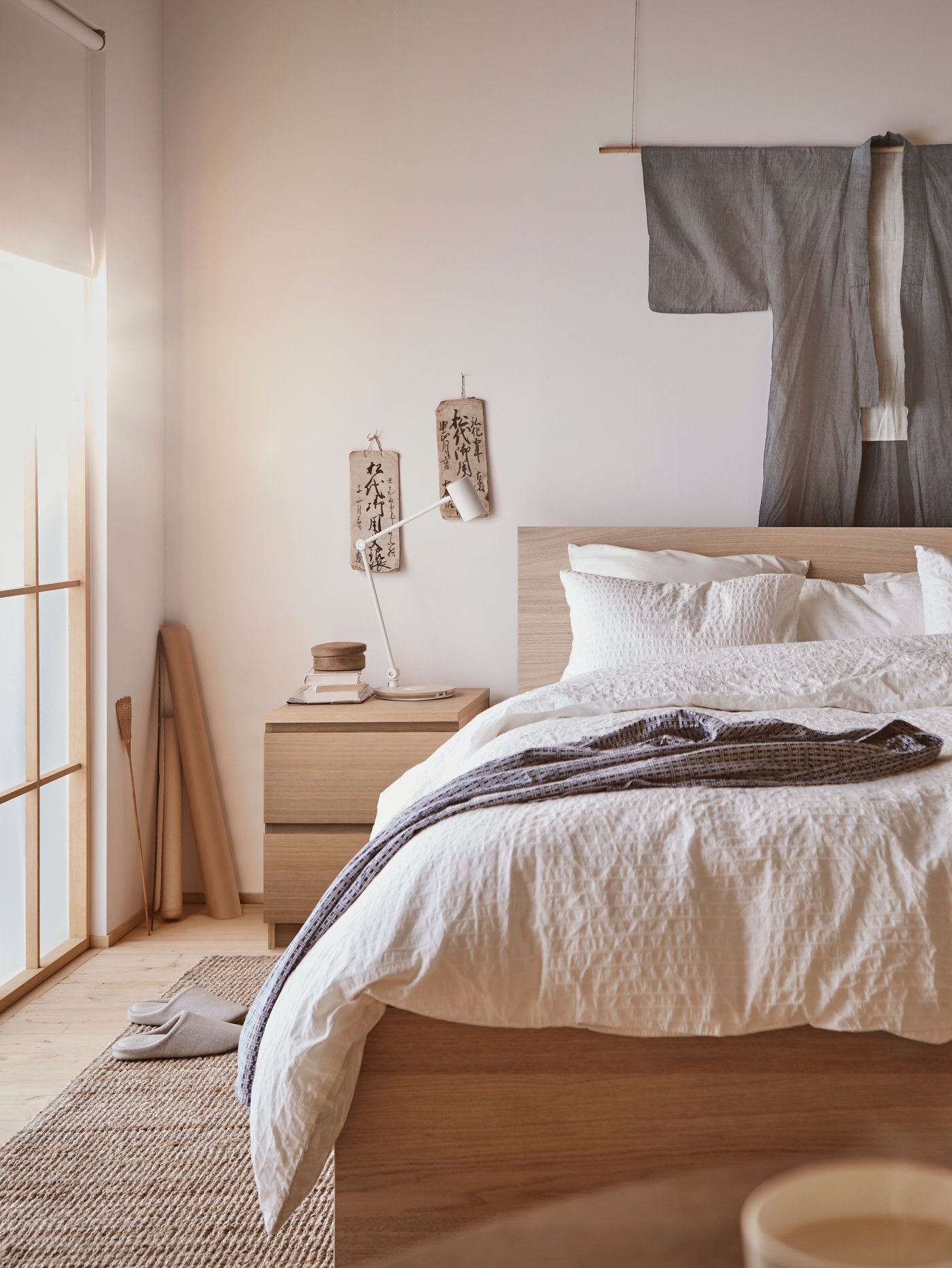 Chambre à coucher japandi avec lit et table de chevet en bois et linge de lit blanc