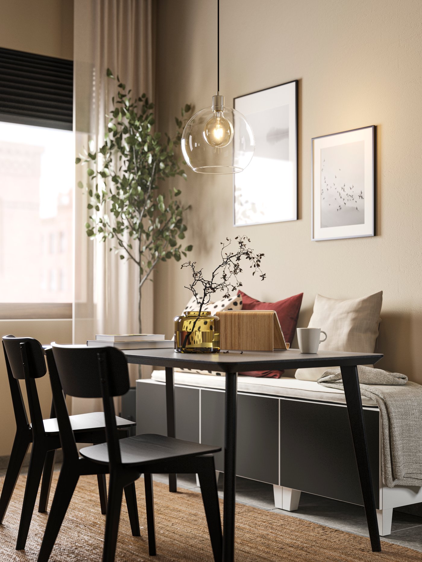 Un comedor negro con dos sillas LISABO frente a un sofá esquinado con cojines encima.
