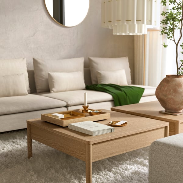 A light-coloured, modern living room has a beige 3-seat SÖDERHAMN modular sofa behind two TONSTAD oak veneer coffee tables.