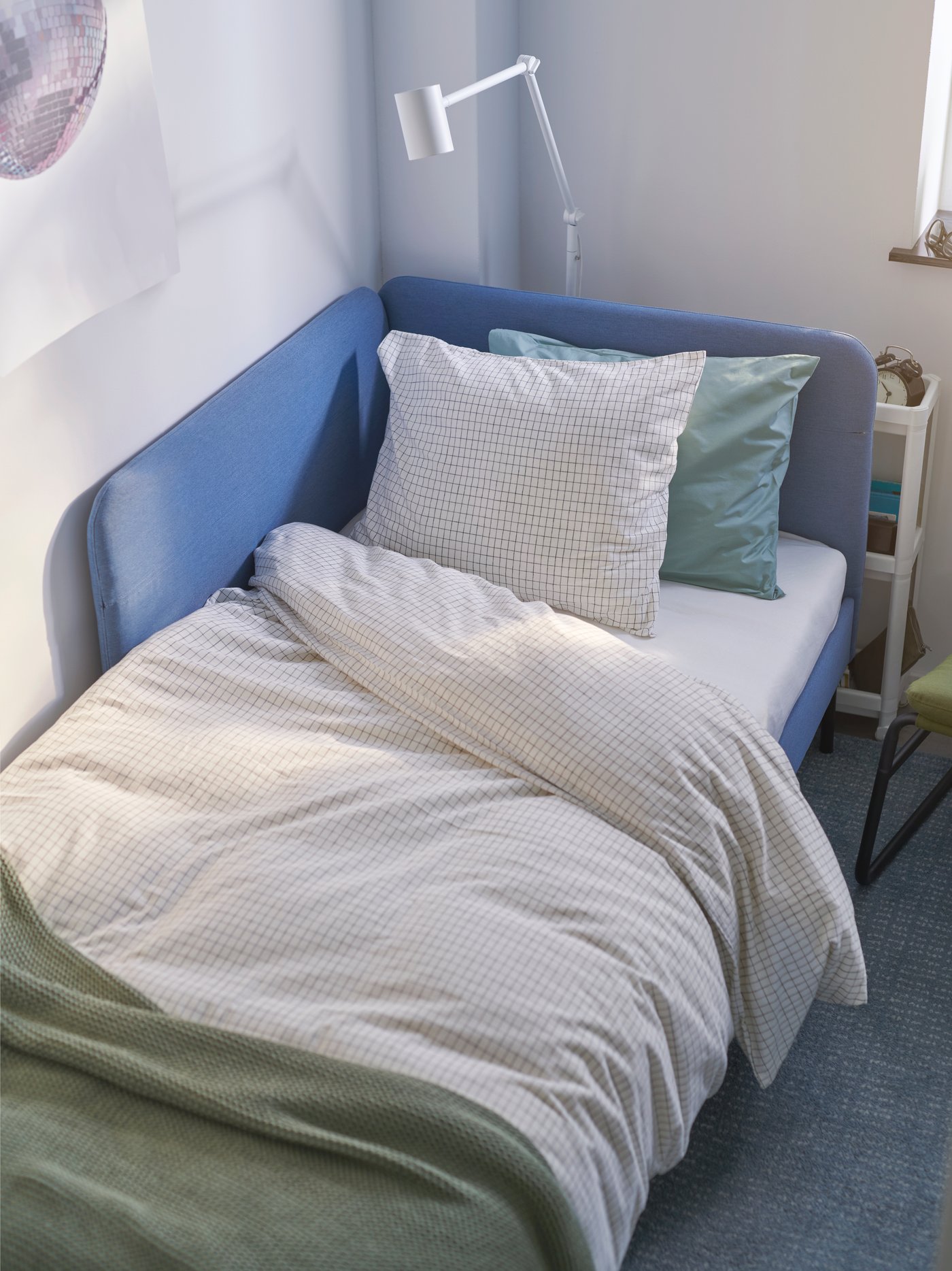 Un sofá cama con plumones y almohadas IKEA.