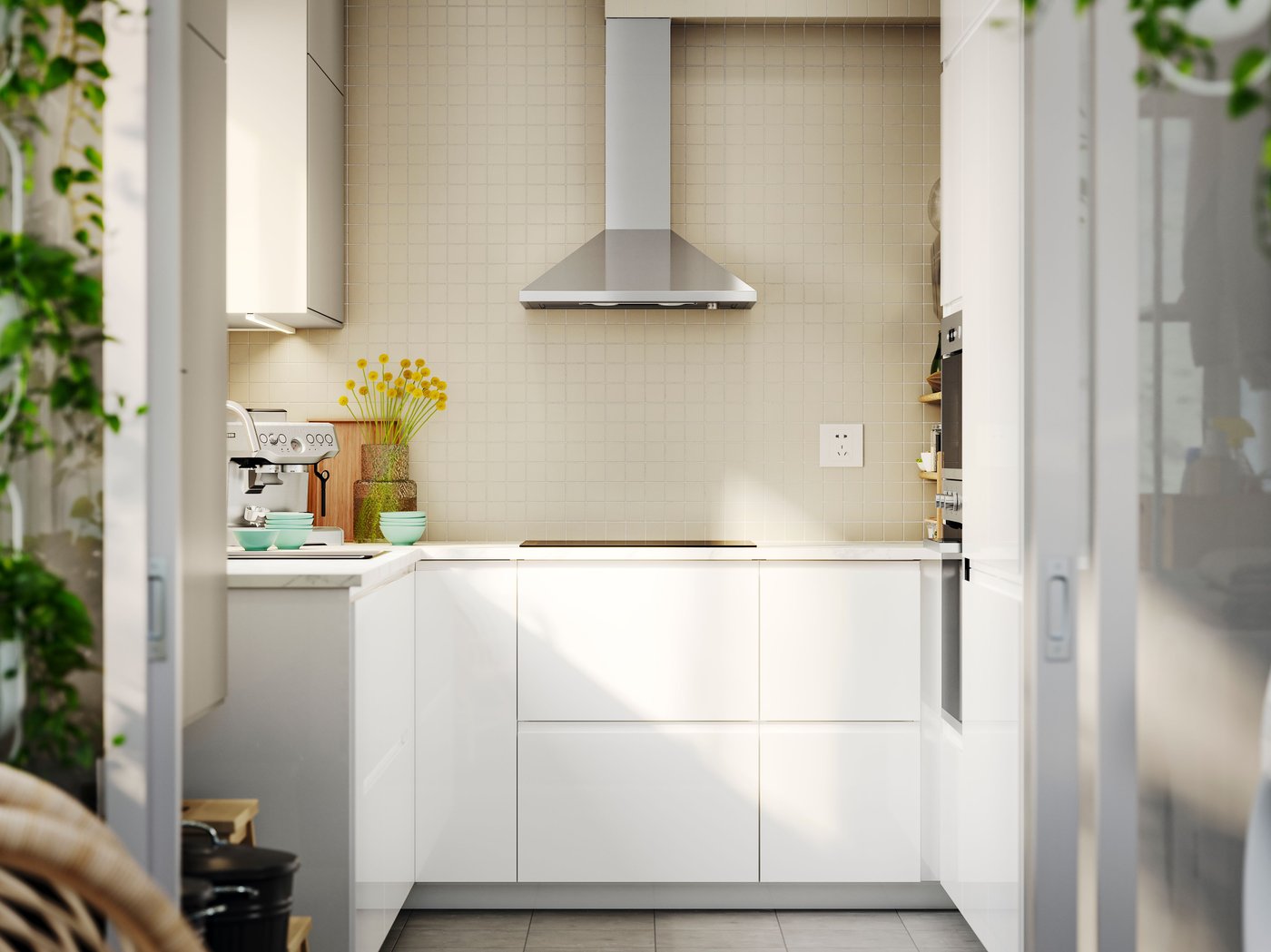A small kitchen with VOXTORP high-gloss white fronts, a stainless steel extractor hood, and small appliances on the worktop.