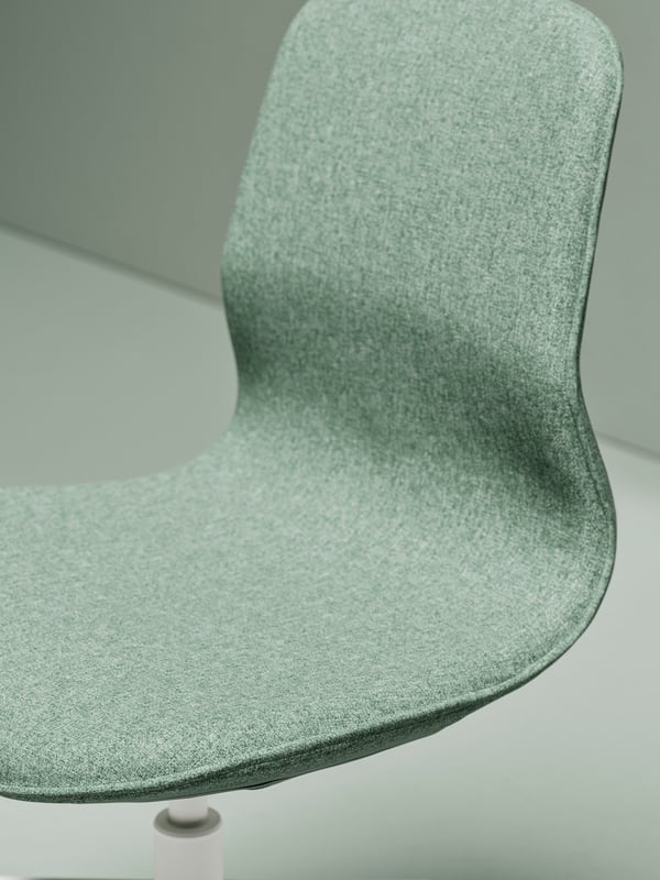 L’assise et le dossier doucement arrondis d’une chaise de conférence sans accoudoirs LÅNGFJÄLL, dans un espace sans mobilier.