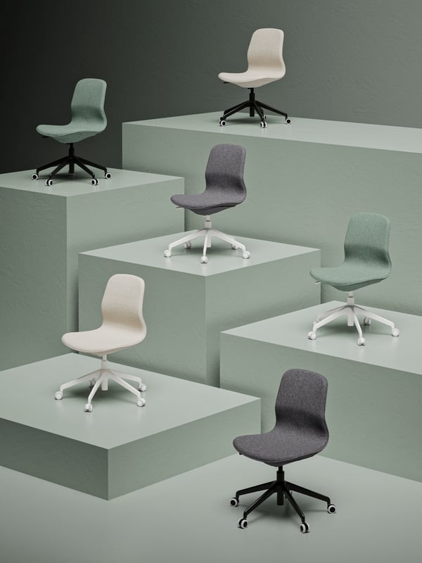 Chaises de conférence sans accoudoirs et à roulettes LÅNGFJÄLL dans des nuances de vert, blanc et gris exposées sur des podiums de différentes hauteurs.