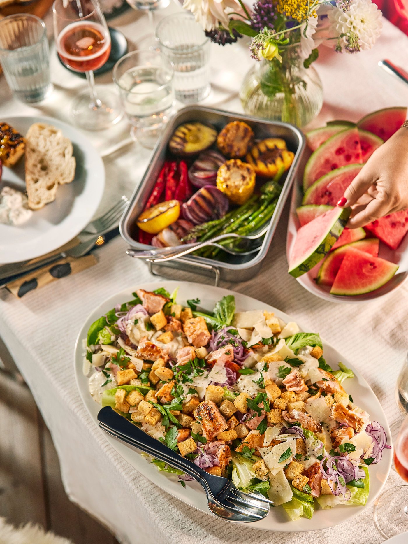 A table with a white tablecloth filled with different dishes.