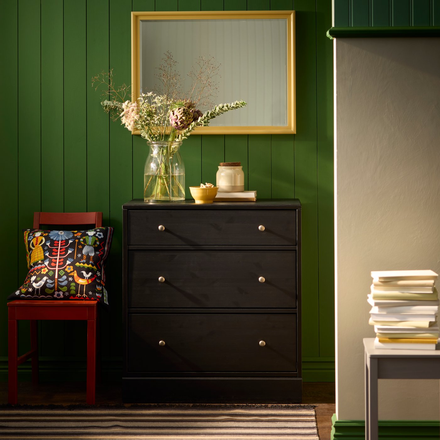 A black HAVSTA chest of 3 drawers is positioned against a green wall and under a PINGSTSYREN mirror.