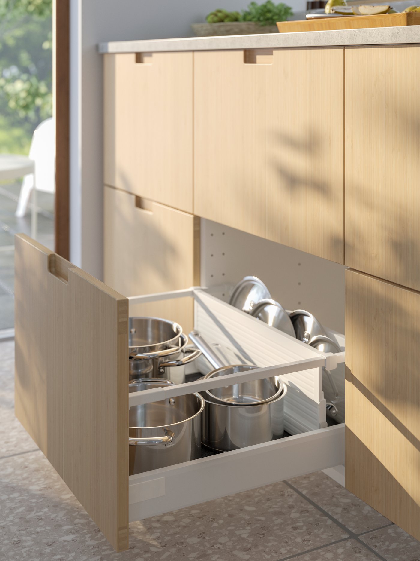 In an open kitchen drawer, an UPPDATERA divider for drawer separates IKEA 365+ pots and saucepans from their lids.