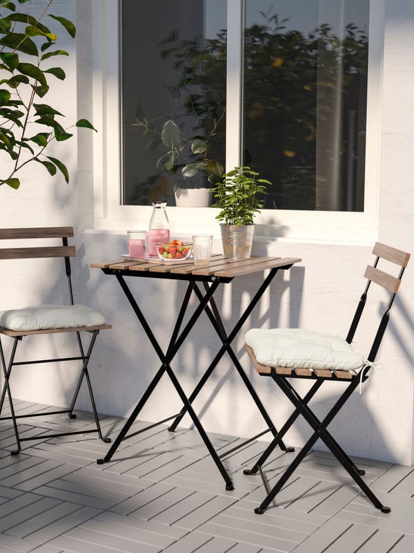Un juego de comedor para balcón TÄRNÖ con una mesa y dos sillas plegables. 