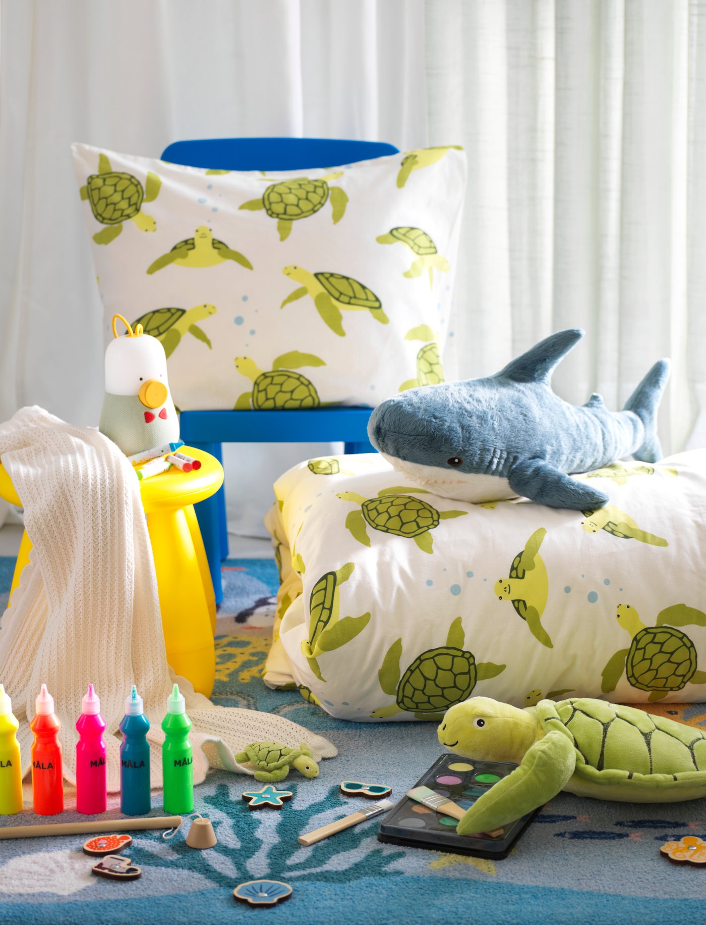 Una habitación infantil con textiles BLÅVINGAD y peluches.