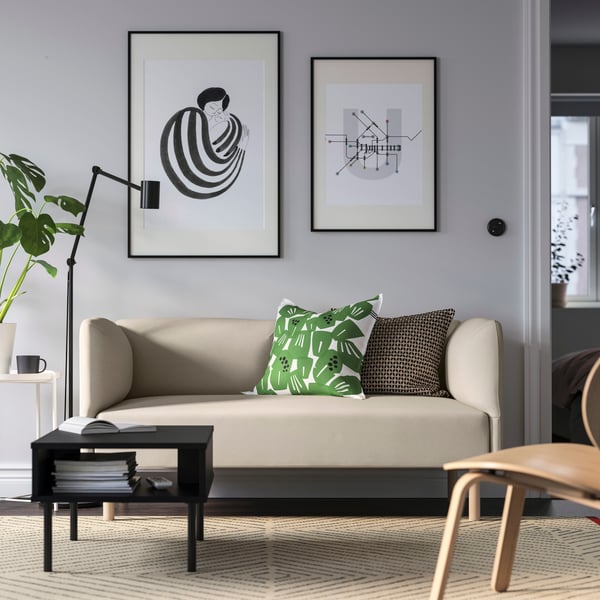 Sofá beige LILLEHEM con un cojín con diseño con plantas.